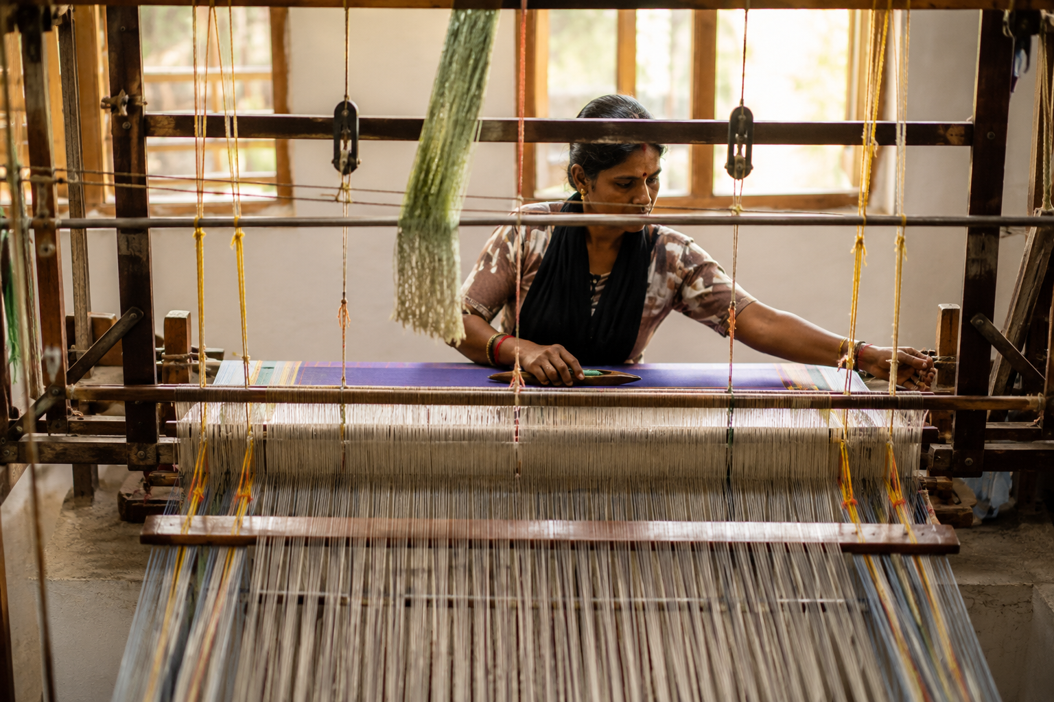 Artisan weaving at a traditional loom in Arani